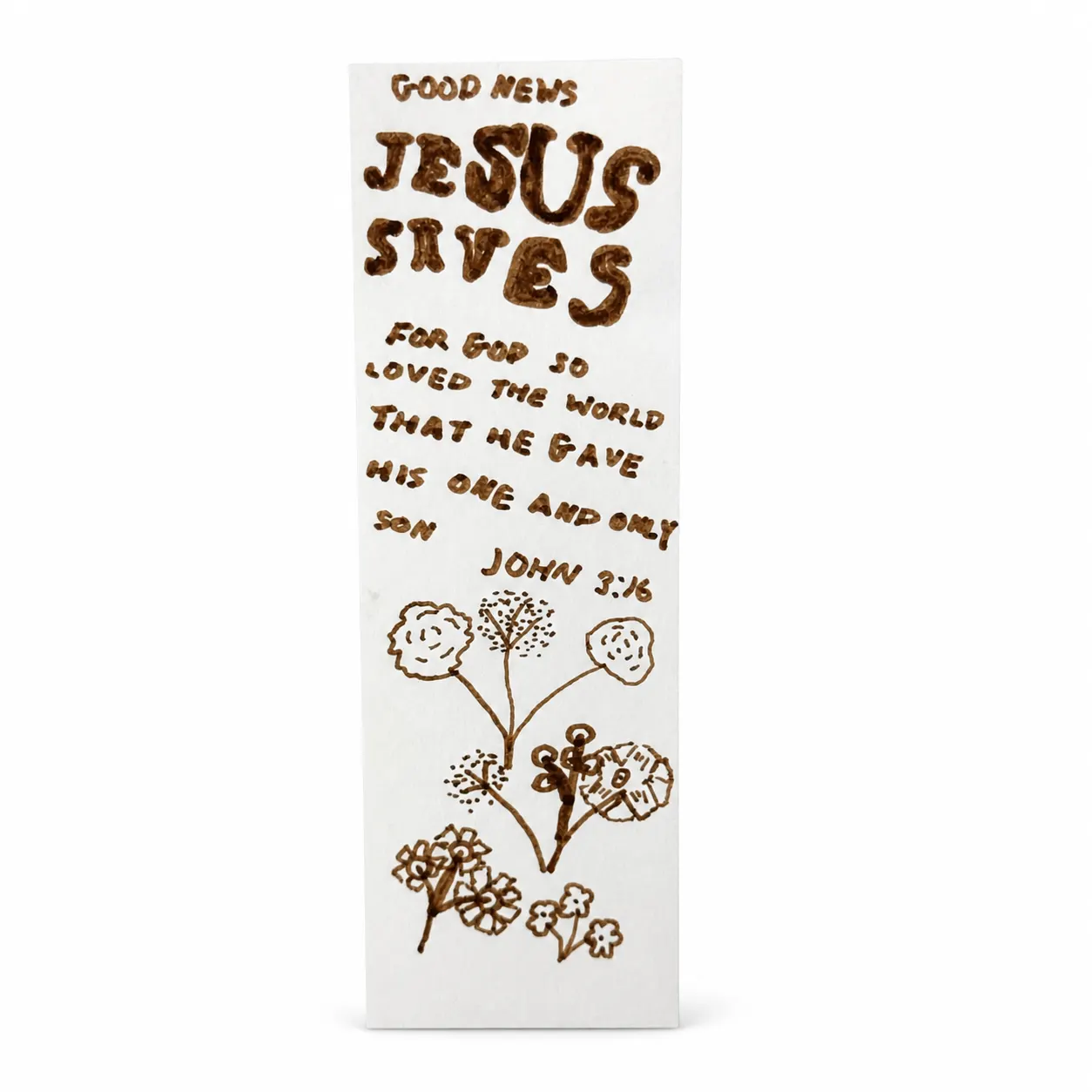 A white card in brown marker reading Good News above Jesus Saves in rounded bubble letters, followed by John 3:16 hand-written in full, above a hand-drawn spray of flowers and seed heads.